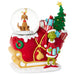 Decorative Christmas scene with a sleigh, Grinch, and snow globe on a white background