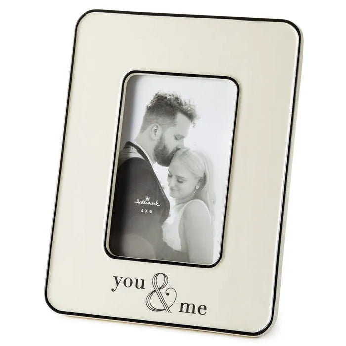 Cream photo frame with 'you & me' engraving holding a black and white photo of a couple.