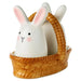 Ceramic rabbit figurine salt and pepper shaker  inside a woven basket on a white background