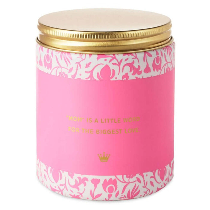 Pink candle with gold lid and decorative patterns on a white background