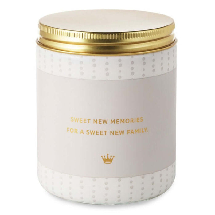 Candle jar with gold lid and text 'Sweet New Memories for a Sweet New Family' on a white background