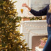Woman holding Resin Slice of Pepperoni Pizza Hallmark Ornament , posing as if it is being put on a Christmas Tree.