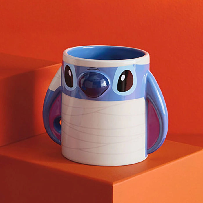 Blue and white mug with cartoon character face of Stitch for the beloved Disney Movie Lilo and Stitch. on an orange background