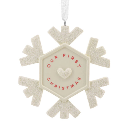 Decorative ornament with 'Our First Christmas' text on a white background