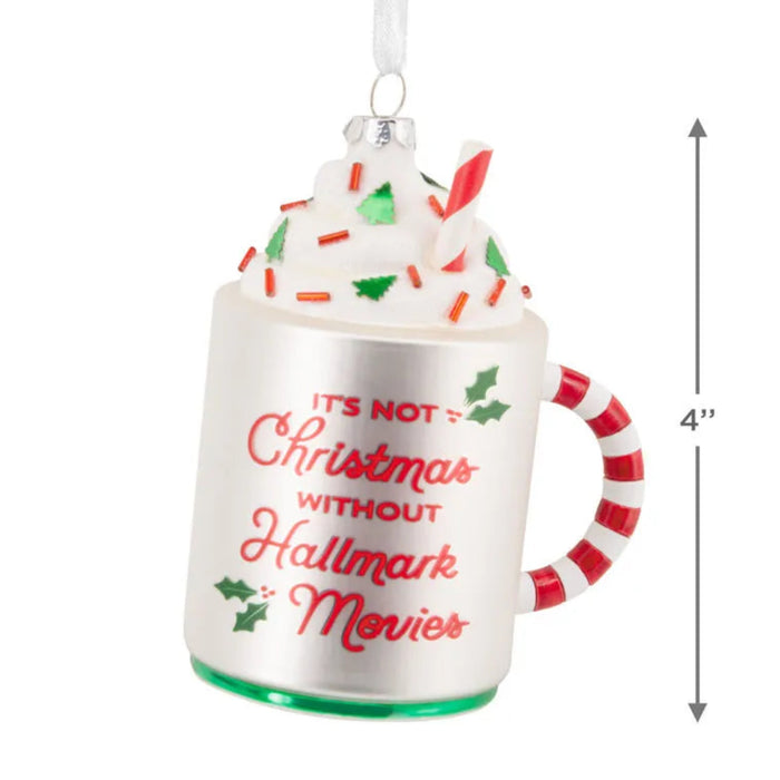 Decorative ornament shaped like a mug with whipped cream, candy canes, and text 'It's Not Christmas Without Hallmark Movies'.