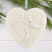Heart-shaped ceramic ornament with floral patterns hanging on a branch.