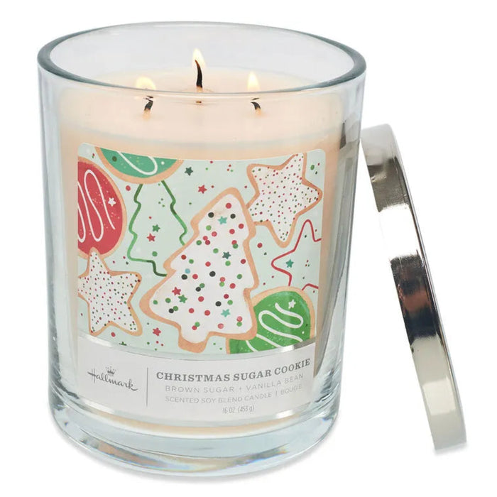 Hallmark 3 wick Candle in a glass jar with a Christmas-themed label featuring cookies, on a white background.