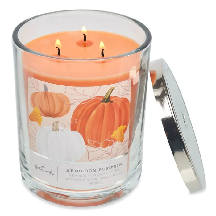  Hallmark Three-wick candle in a glass jar with a pumpkin design label, on a white background.
