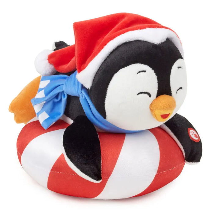 Plush penguin toy wearing a Santa hat  Laying on a striped sled on a white background