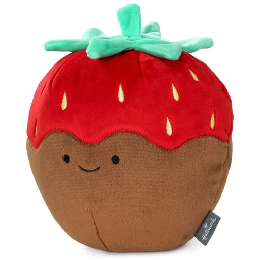Front view of a smiling chocolate-covered strawberry plush with red strawberry top, embroidered yellow seeds, and green fabric leaves.