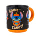 Black mug with orange handle featuring a Halloween-themed design of a character  Stitch in a pumpkin with 'Gimme Candy!' text.