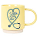 Yellow mug with a stethoscope design and text 'A caring HEART A giving SOUL' on a white background