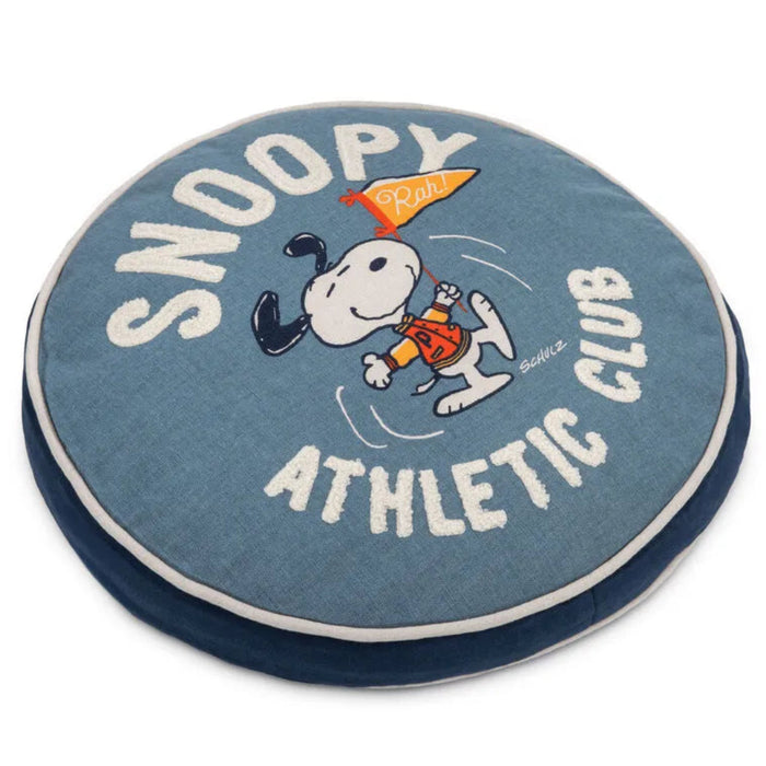 Round pillow with Snoopy and 'Snoopy Athletic Club' text on a blue background