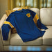 Blue sweatshirt with yellow accents on a beige couch
