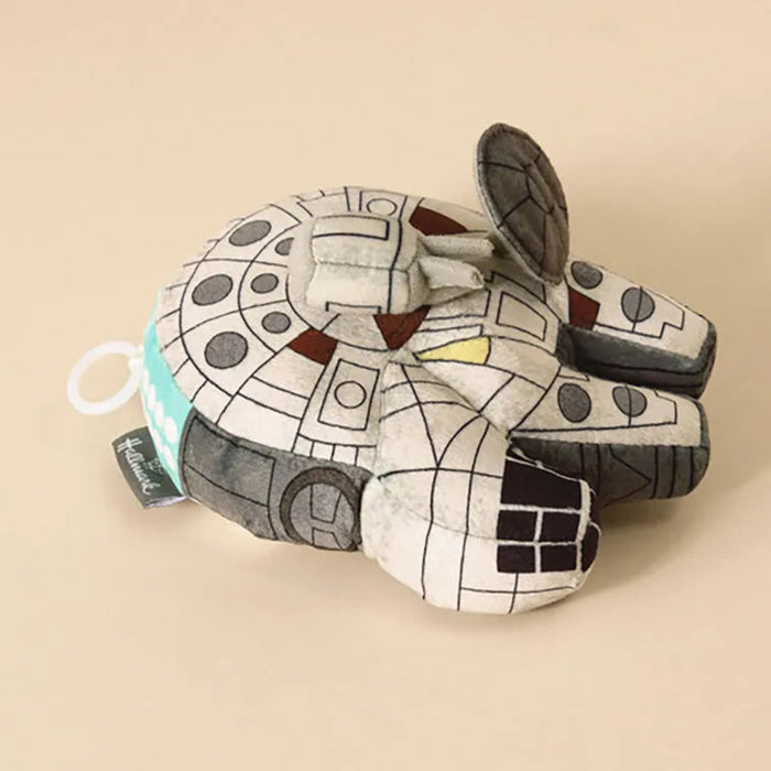 Plush toy resembling a robot or vehicle on a beige background