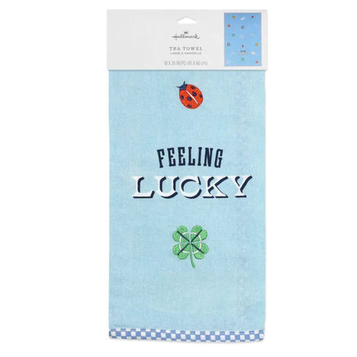 Tea towel with 'Feeling Lucky' text and four-leaf clover design on a blue background