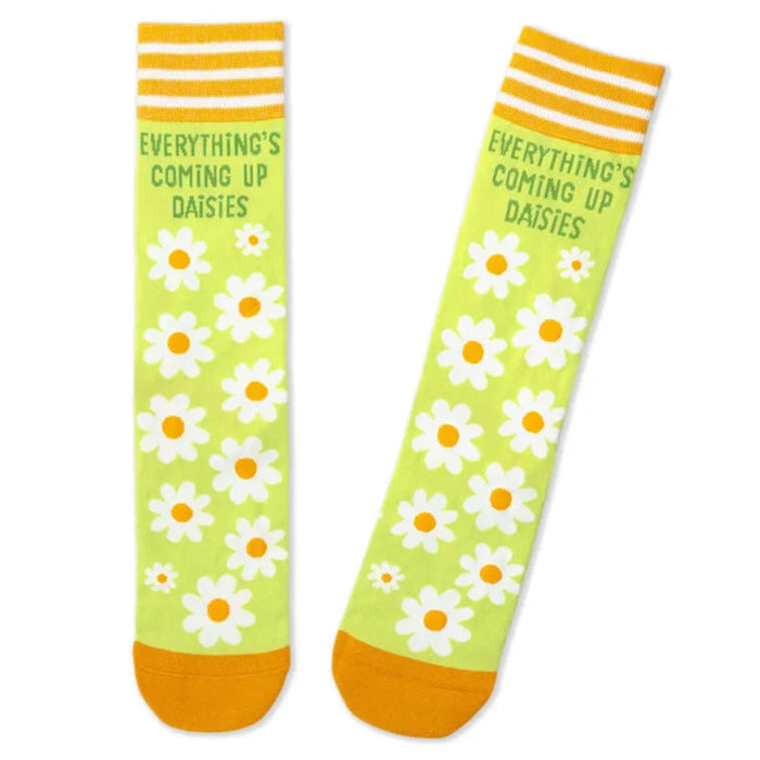 Green socks with white daisy flowers and yellow accents on a white background