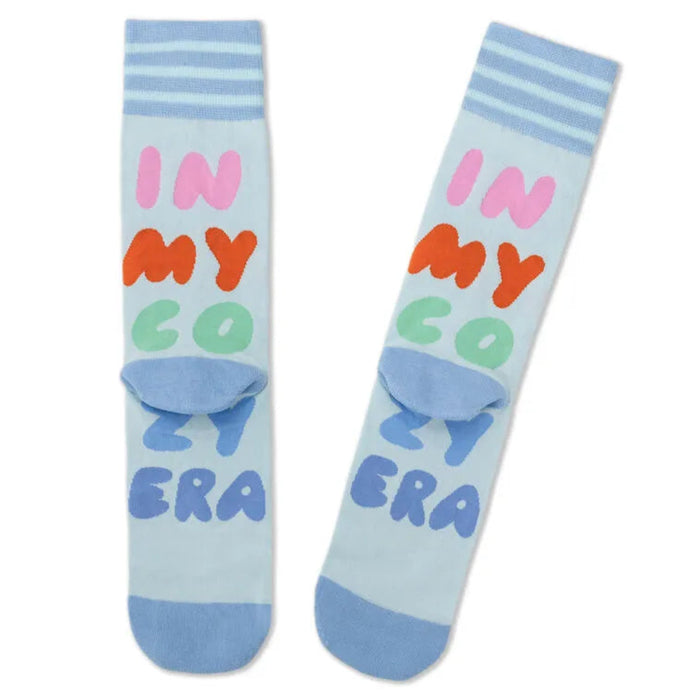 Light blue socks with colorful text 'IN MY COZY ERA' on a white background
