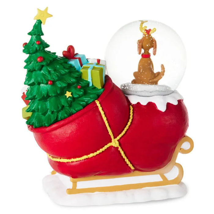 Decorative Christmas ornament with a sleigh, Christmas tree, presents, and a snow globe with a dog on a white background.