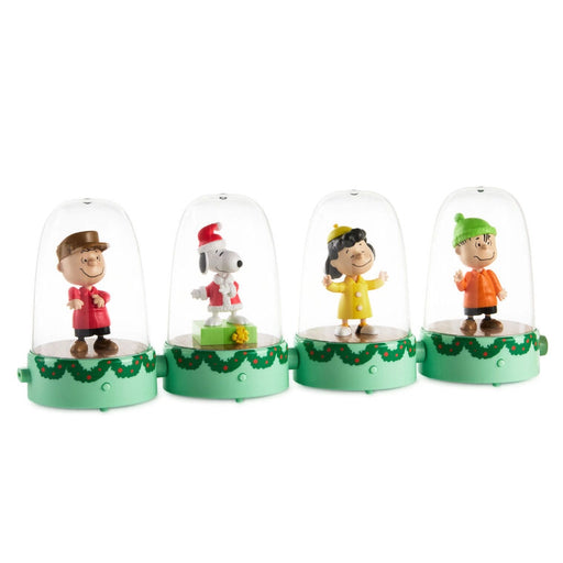 Four small figurines under glass domes on a white background