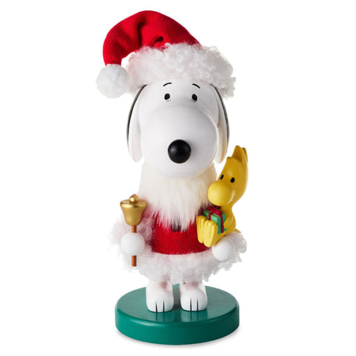 Snoopy figurine wearing a Santa hat with a yellow dog and bell on a white background