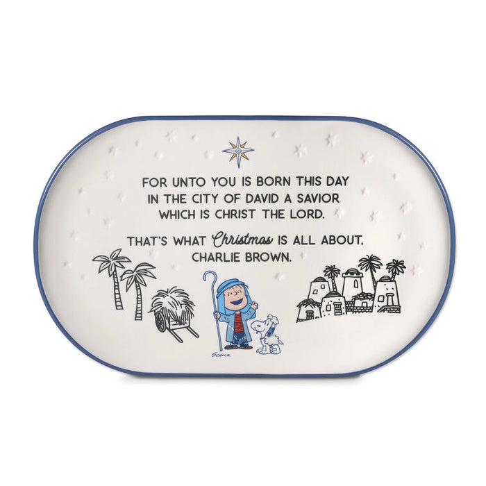 Decorative plate with Christmas-themed design featuring Charlie Brown and Snoopy, with text about Christmas and the birth of Christ.