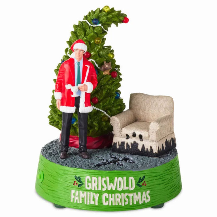 Christmas-themed figurine with a man in a red coat, tree, and chair on a white background.