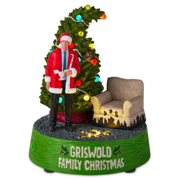 Decorative figurine with a man in a Santa suit next to a Christmas tree, sitting on a chair, with 'Griswold Family Christmas' text.
