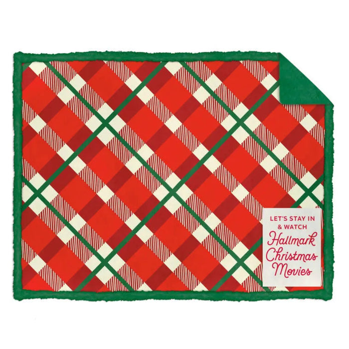 Red and green plaid blanket with a Hallmark Christmas Movies tag on a white background