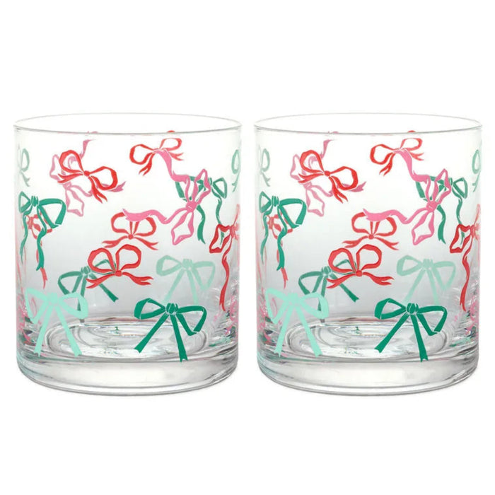 Two clear glass tumblers with colorful bow pattern on a white background