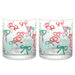 Two clear glass tumblers with colorful bow pattern on a white background