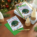 Christmas cards with 'Peace on Earth' design on a wooden table with festive decorations.