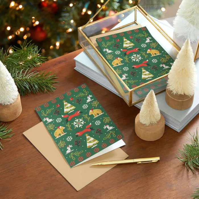 Christmas-themed greeting cards with envelopes on a wooden surface with decorative elements.