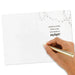 Hand holding a gold pen over a card with text on a white background