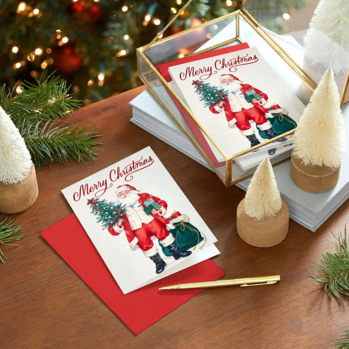 Christmas cards with Santa Claus on a wooden table with festive decorations.