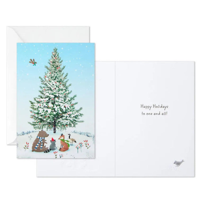 Holiday card with a snowy tree and animals, featuring a white envelope.