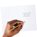 Hand writing on a card with a gold pen
