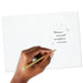 Hand writing on a card with a gold pen, featuring a holiday message.