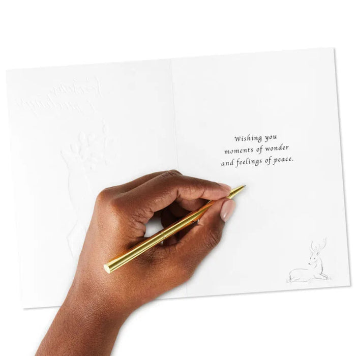 Hand holding a gold pen over a card with text and a rabbit illustration.