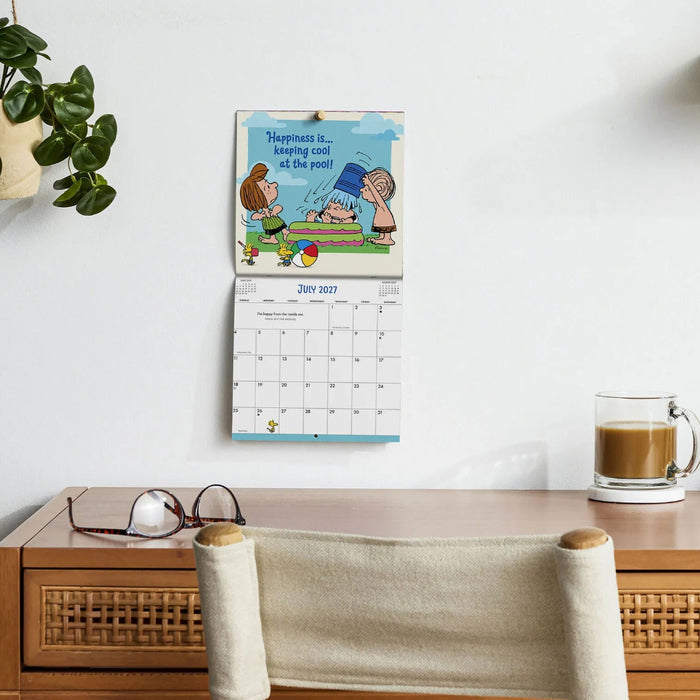 The Hallmark Peanuts® Happiness and Fun 2027 Mini Wall Calendar delivers twelve months of joy, laughter, and uplifting Peanuts® art in a compact 7x7 format.