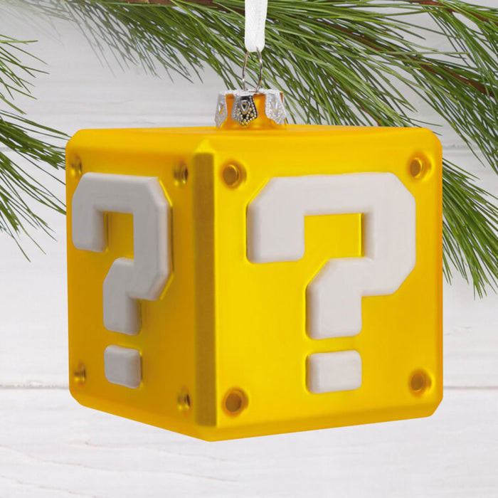 Yellow question mark block ornament with white question marks on a Christmas tree.