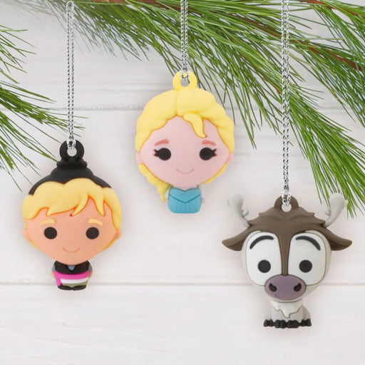 Three  Frozen cartoon character ornaments hanging on a branch on a white background