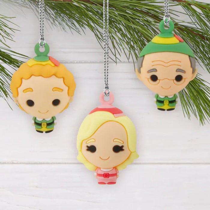 Three colorful  Elf  themed Christmas ornaments hanging on a branch with a white background