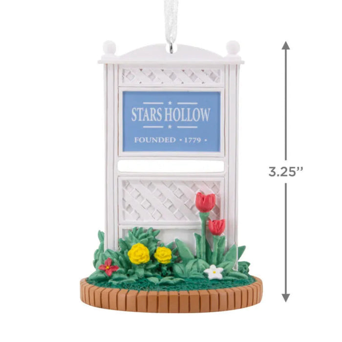 Decorative ornament with 'Stars Hollow' sign and flowers, featuring dimensions on a white background.