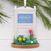 Decorative ornament with 'Stars Hollow' sign and flowers, hanging on a branch against a white background.