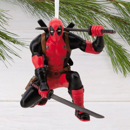 Deadpool Christmas ornament holding a sword against a white background with greenery.
