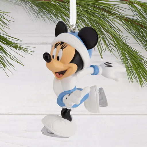Disney Minnie Mouse ornament in a winter outfit with skates hanging on a Christmas tree.