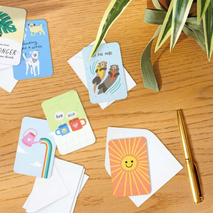 Colorful  Hallmark greeting cards on a wooden surface with a pen and plant
