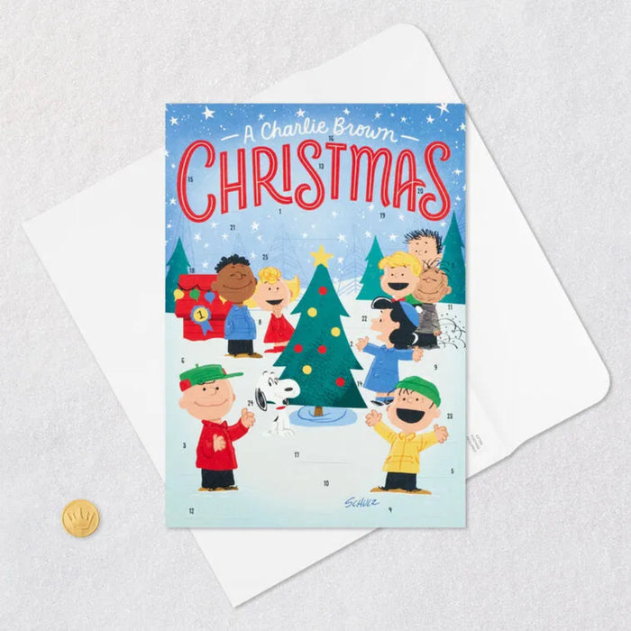 Charlie Brown Christmas card/ Advent Calendar with characters around a Christmas tree on a light blue background