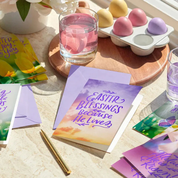 Easter-themed greeting cards with colorful eggs and a glass of water on a table.